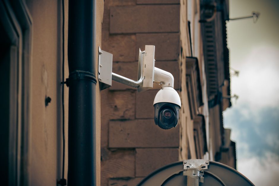Cámara CCTV montada en la pared de un edificio en una calle urbana