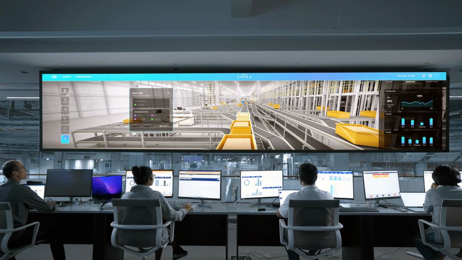 Centro de control moderno con personas monitorizando grandes pantallas y sistemas